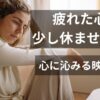 疲れた表情でソファにもたれかかり、物思いにふける女性。「疲れた心を少し休ませる映画｜心に沁みる映画10選」のアイキャッチ画像。